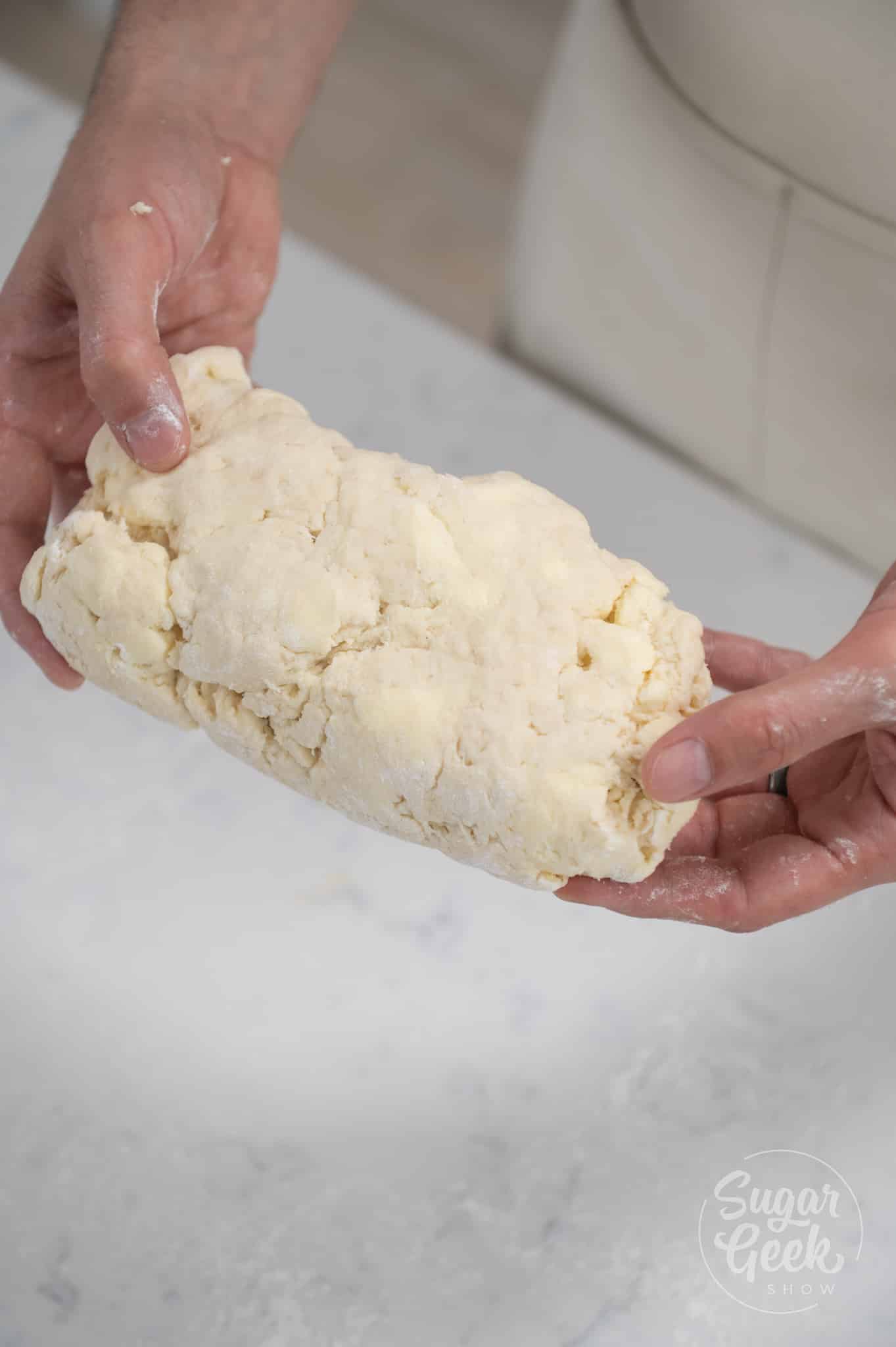 hands holding kneaded dough.
