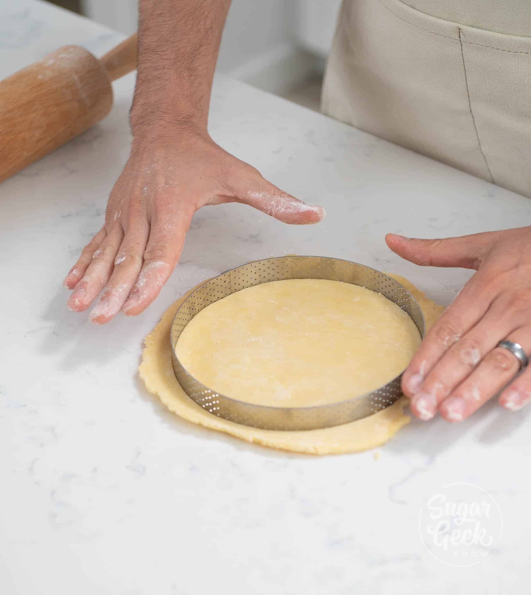 hands using cutter to cut dough