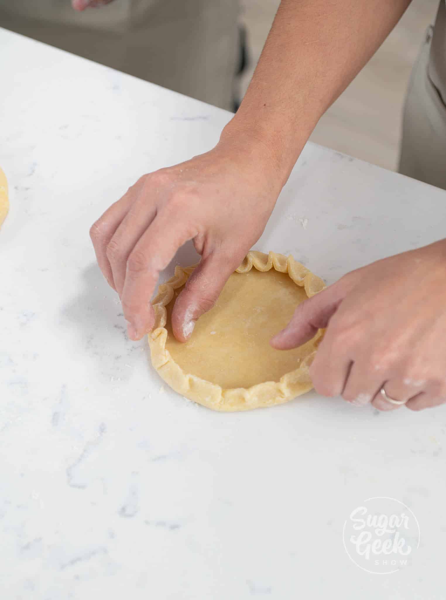 hands folding dough edges.