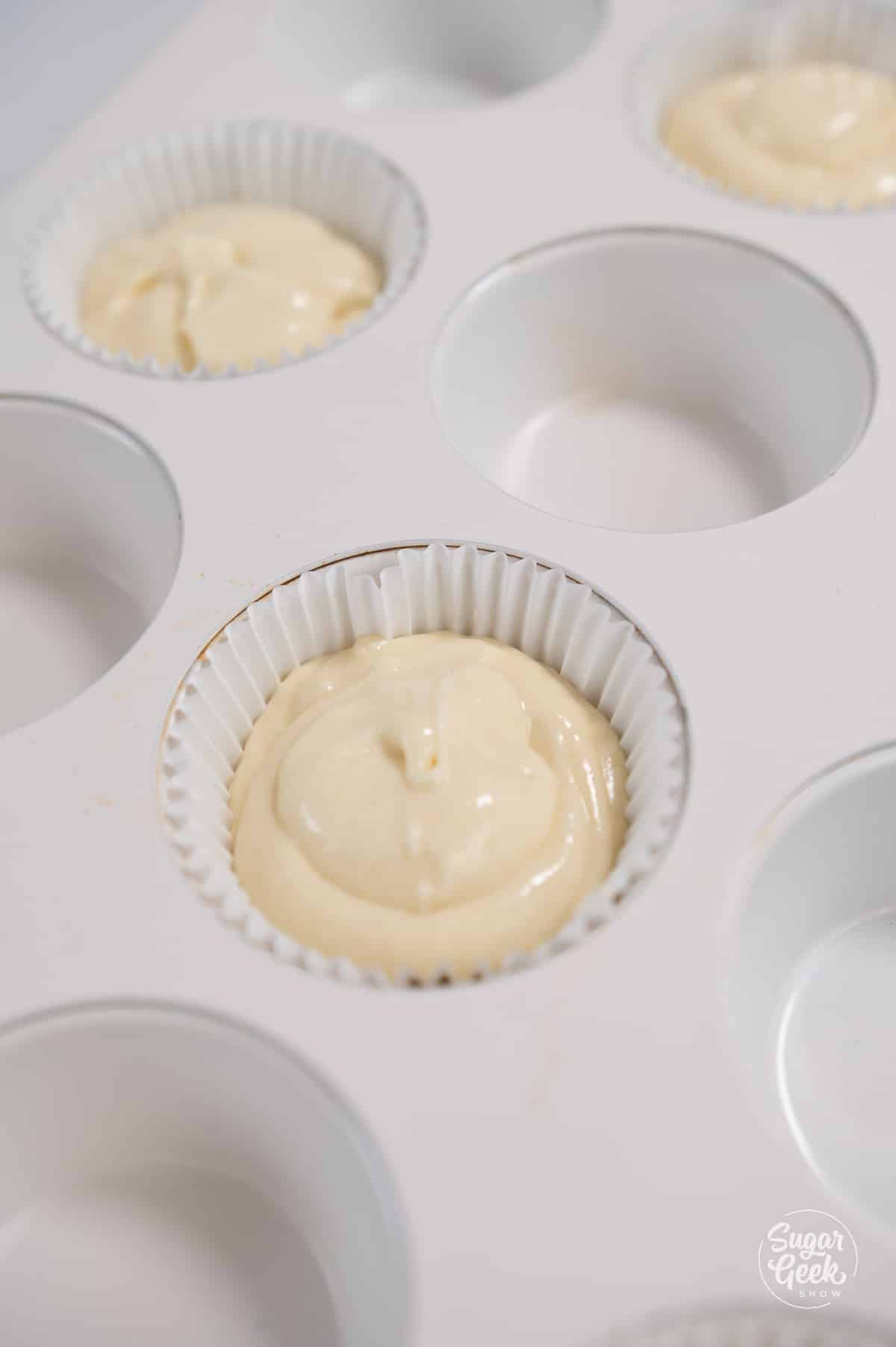 picture of a cupcake pan with batter filled cupcake liners.