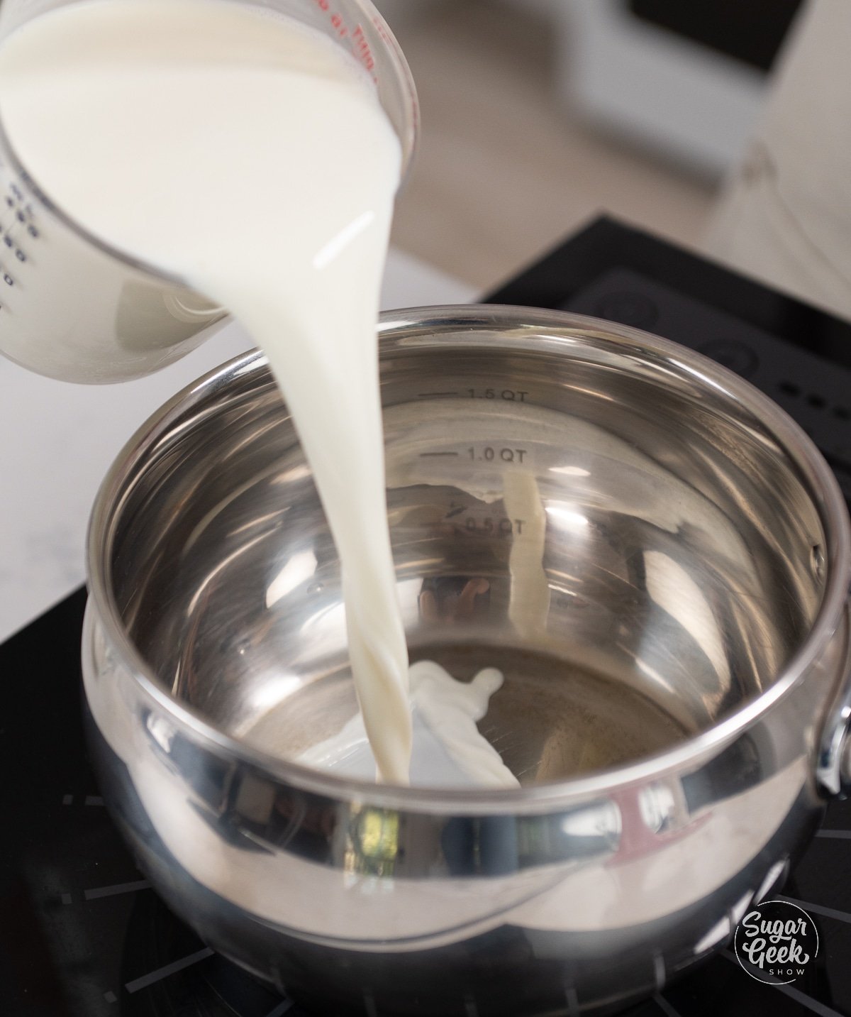 hand pouring milk into medium sauce pan.