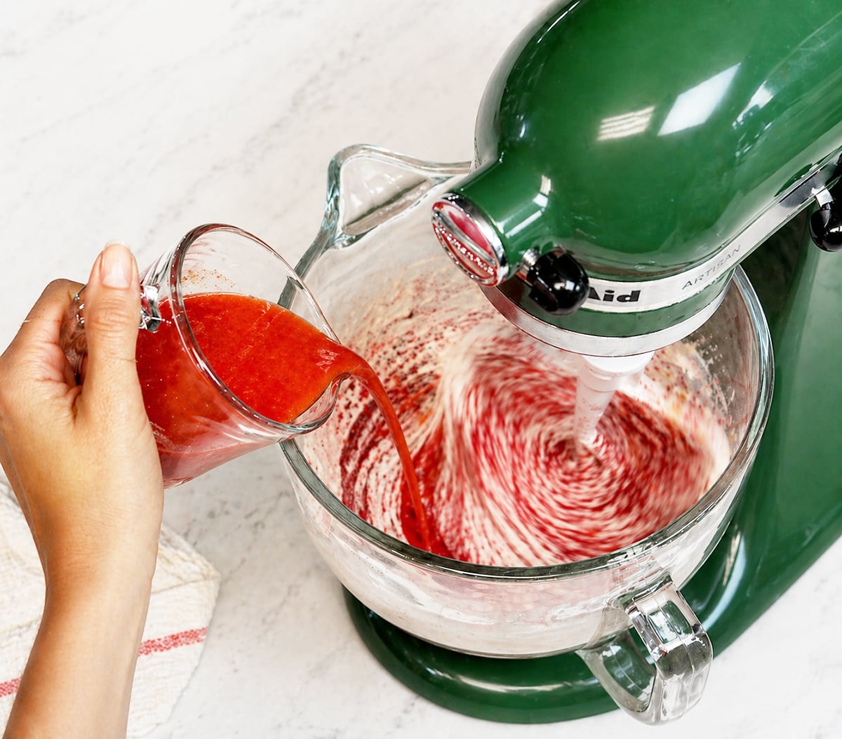 Mixing red velvet cake ingredients in a green stand mixer.