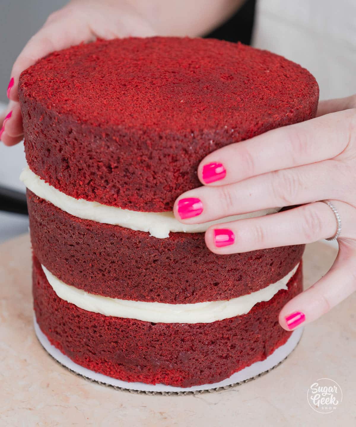 Hand stacking red velvet cake layers