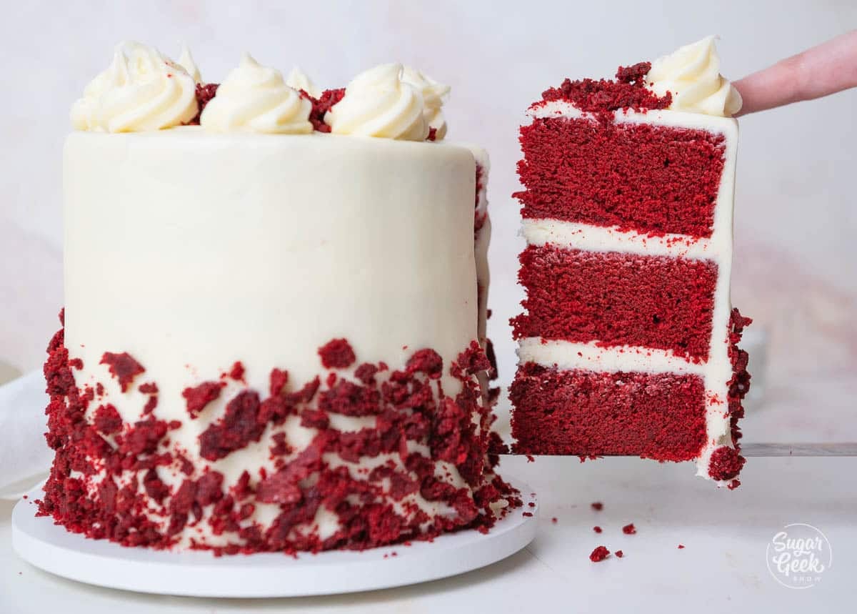 Slice of red velvet cake being removed from the main cake.