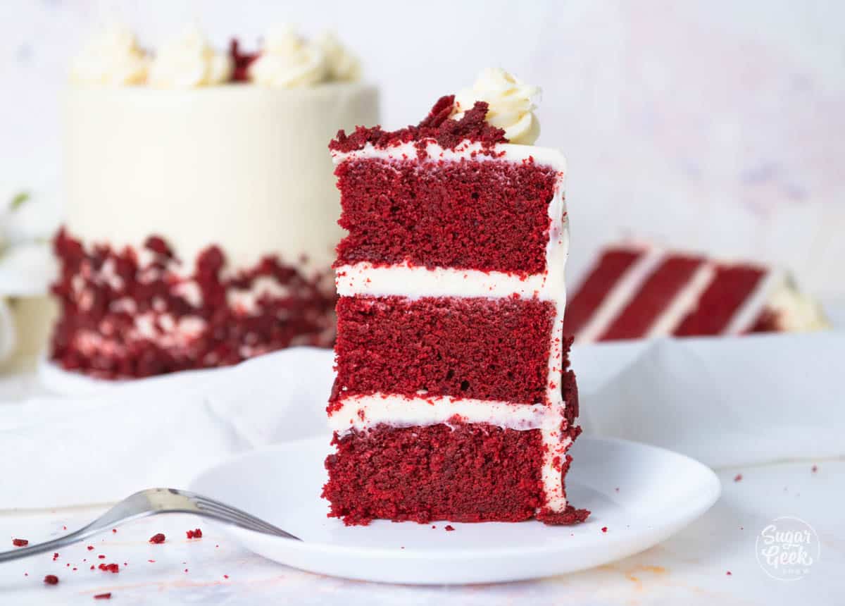 photo of slice of red velvet cake with cake in the background