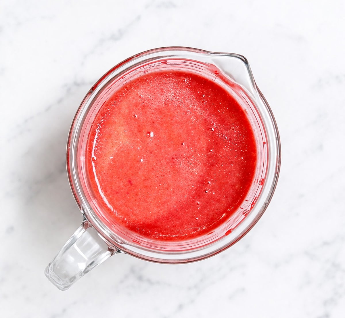 Red velvet cake liquid ingredients in a measuring cup.