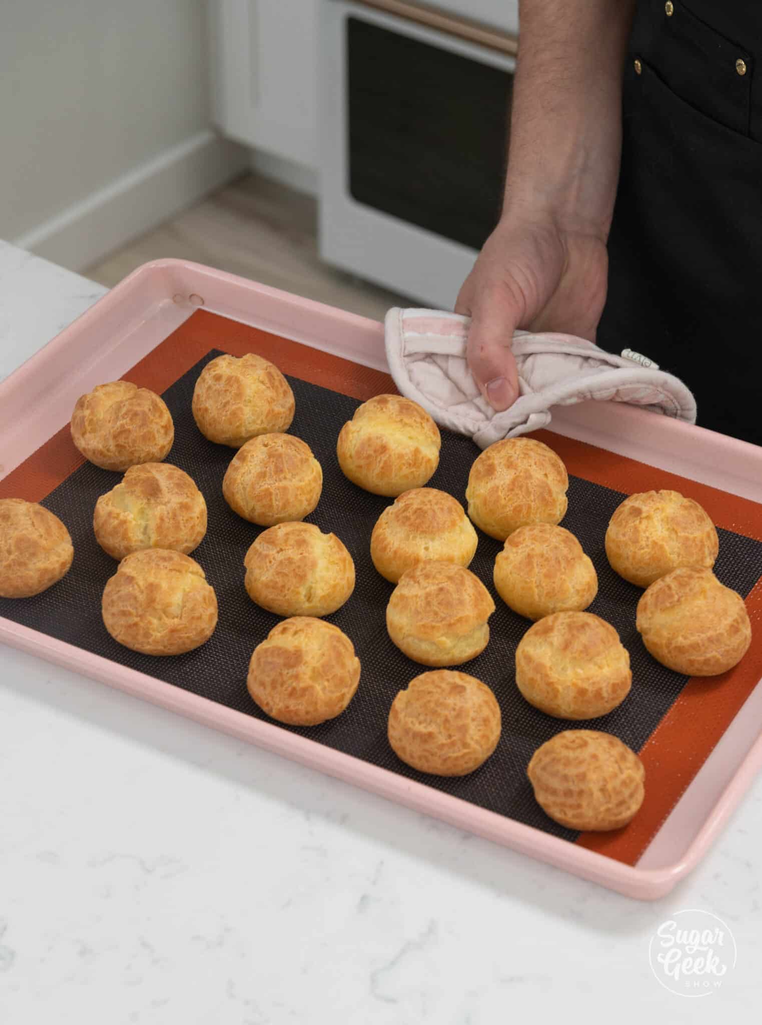 baking tray of finished golden cream puffs