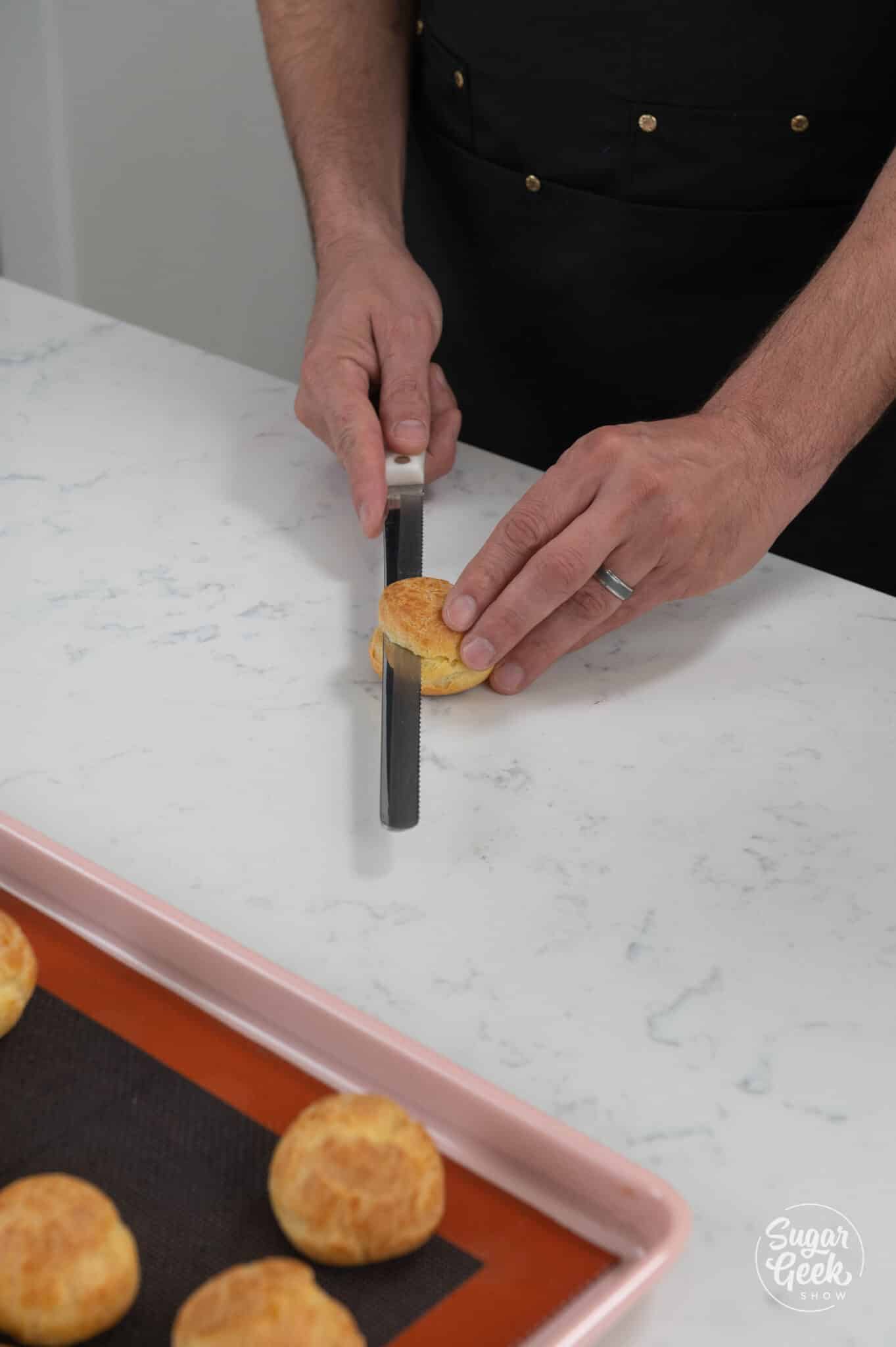 serrated knife cutting through a cream puff