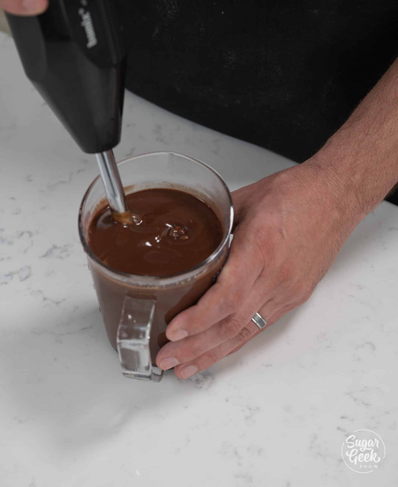 mixing chocolate glaze with an immersion blender