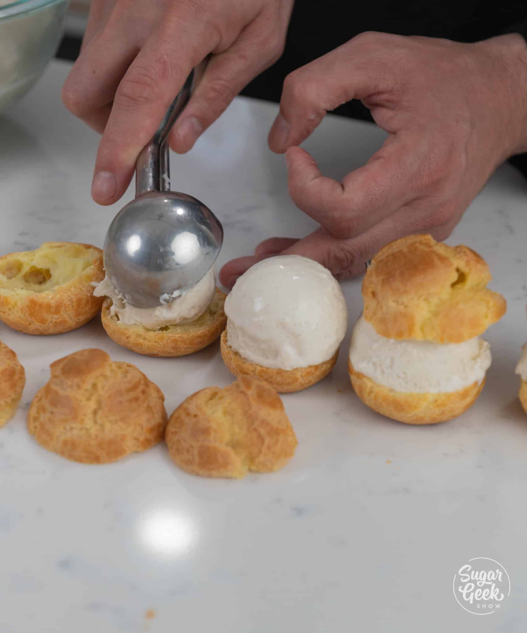placing a scoop of gelato onto the bottom of a cream puff