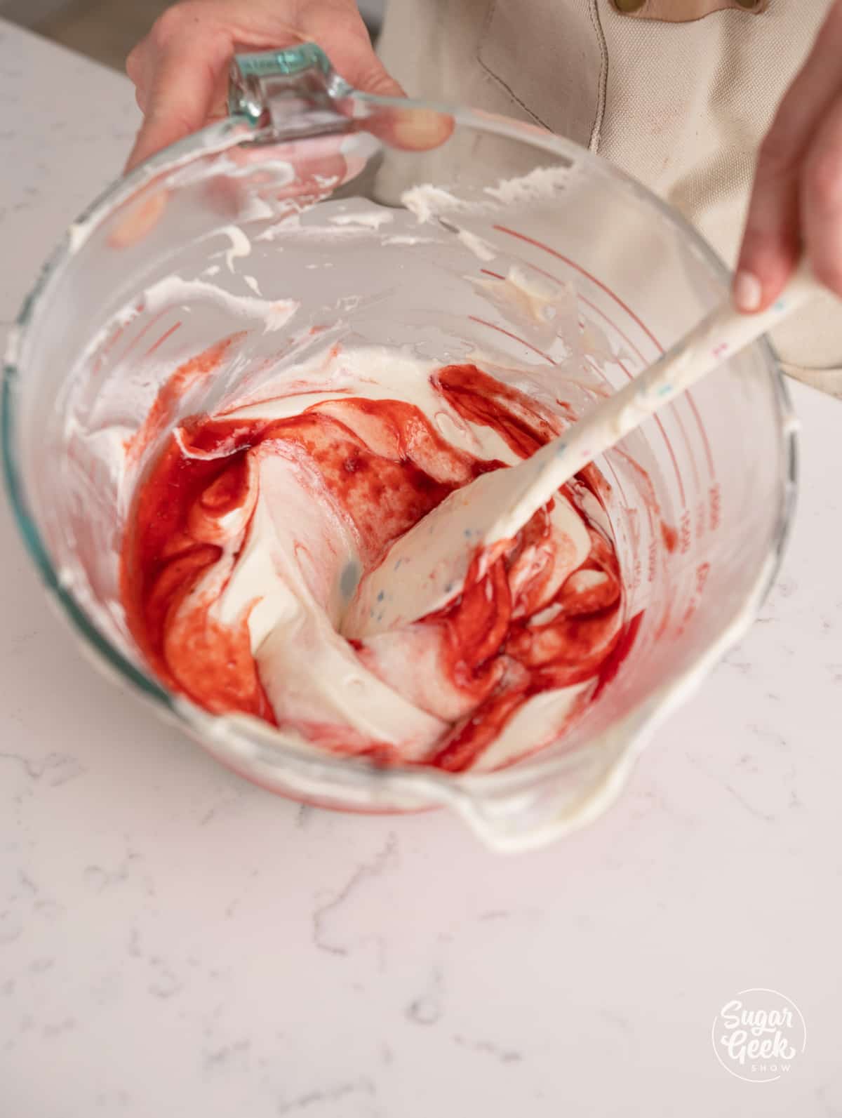 hand mixing strawberry puree and emulsion into cake batter.