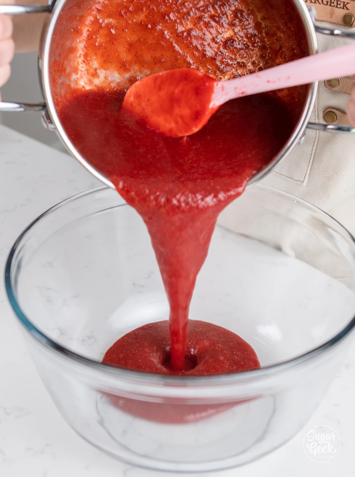 pouring strawberry puree into a glass bowl to cool. 