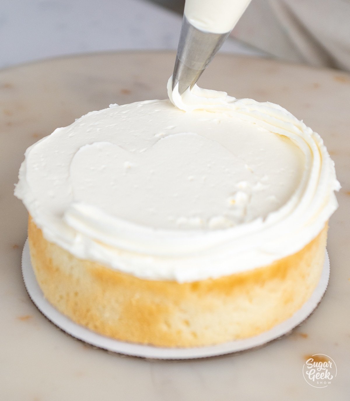 piping a buttercream dam around a layer of cake.