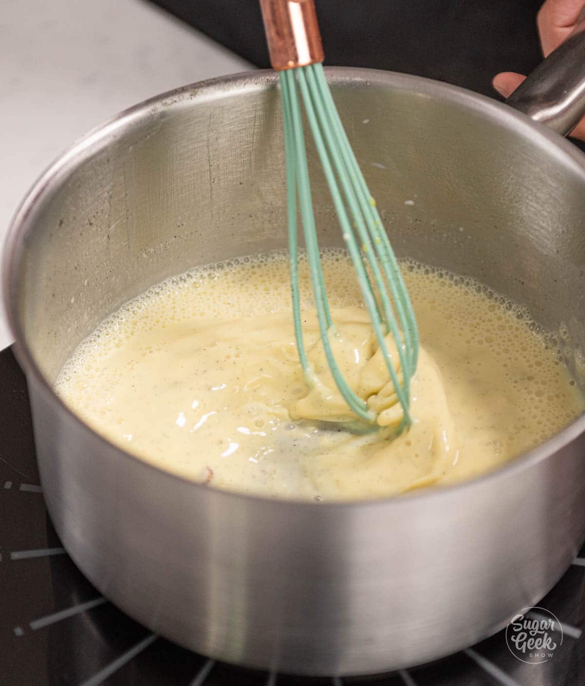 whisking the strained pastry cream mixture over heat for an additional minute. 