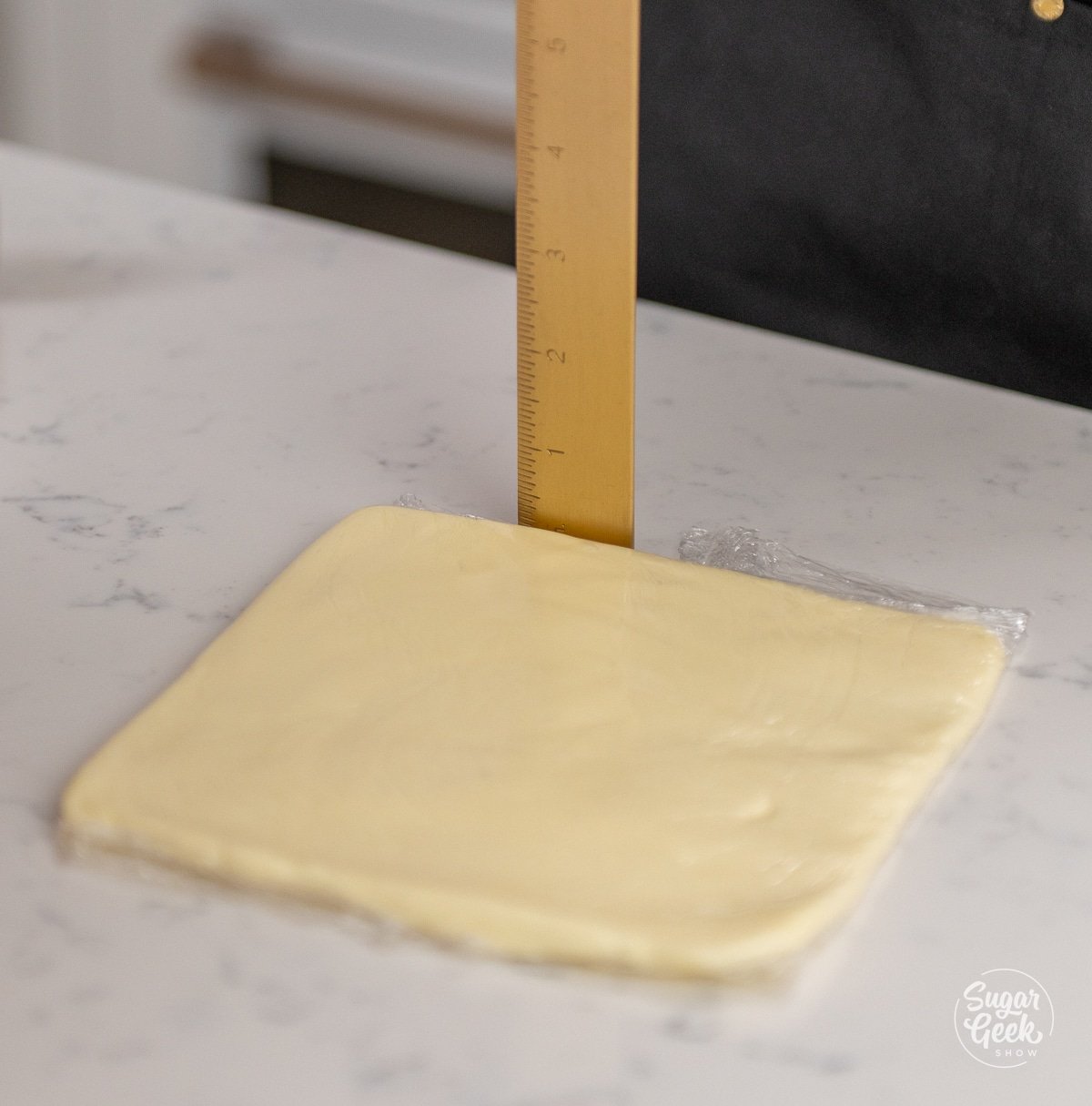 ruler measuring the thickness of a butter block