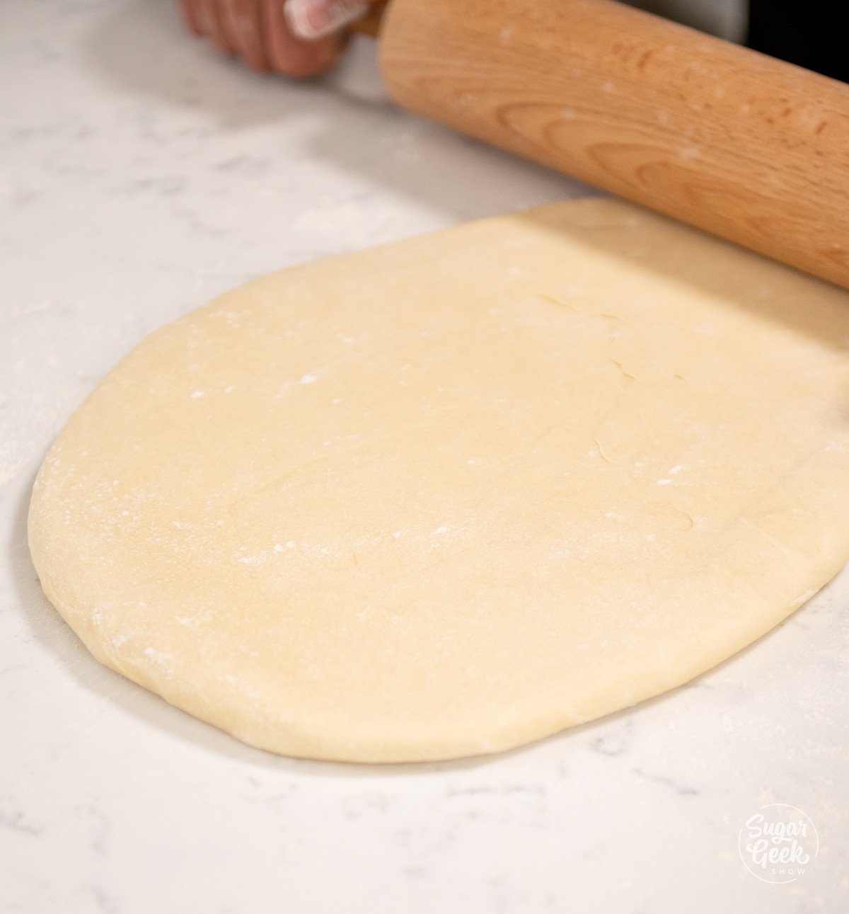 rolling pin pressing on croissant dough