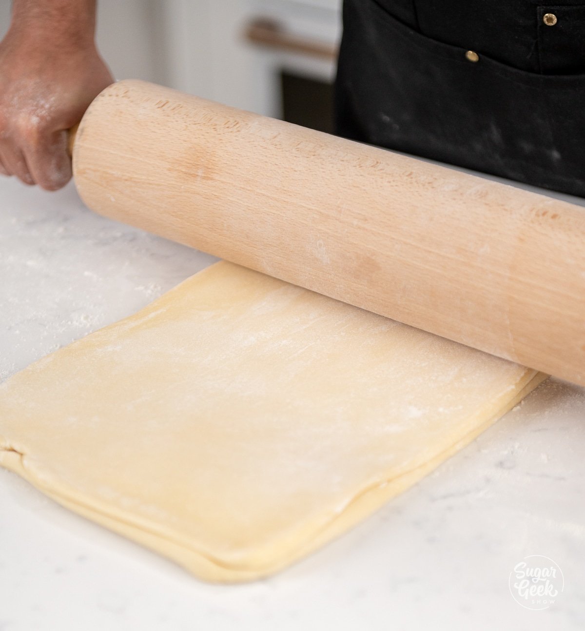 wooden rolling pin rolling croissant dough