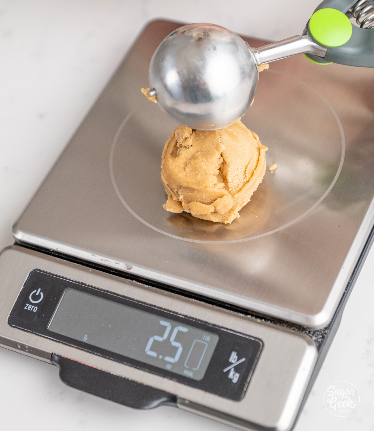 cookie scoop placing a ball of cookie dough onto a food scale