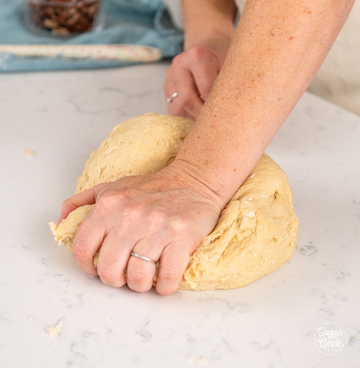 hands pressing down on a ball of dough
