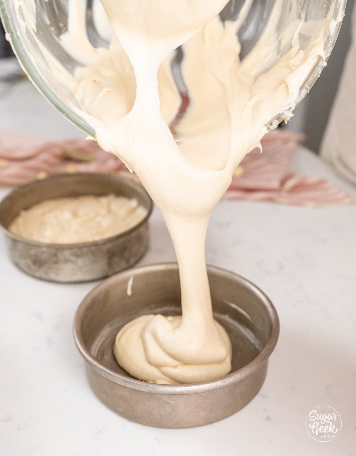 cake batter being poured into cake pans