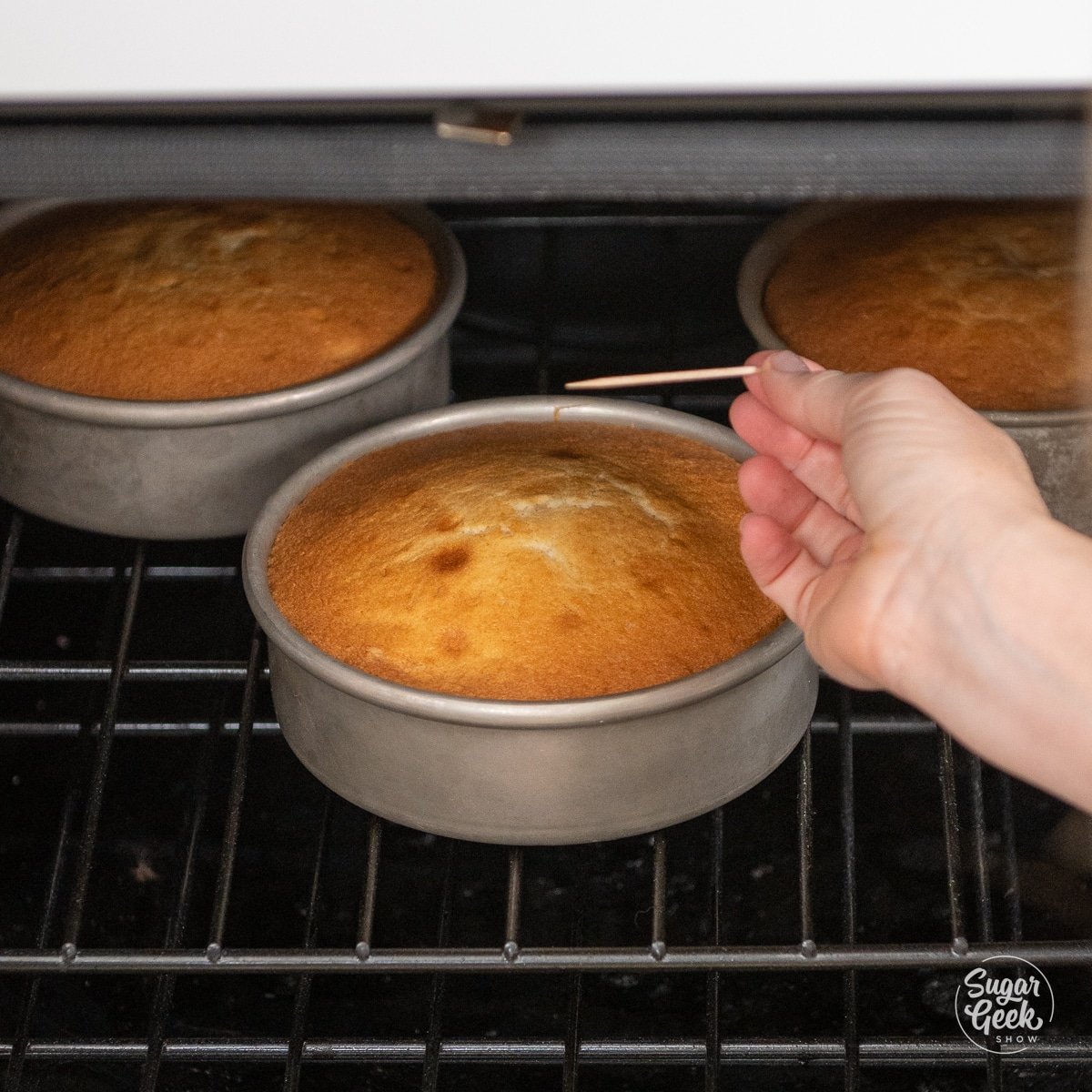 clean toothpick coming out of a baked cake in the oven