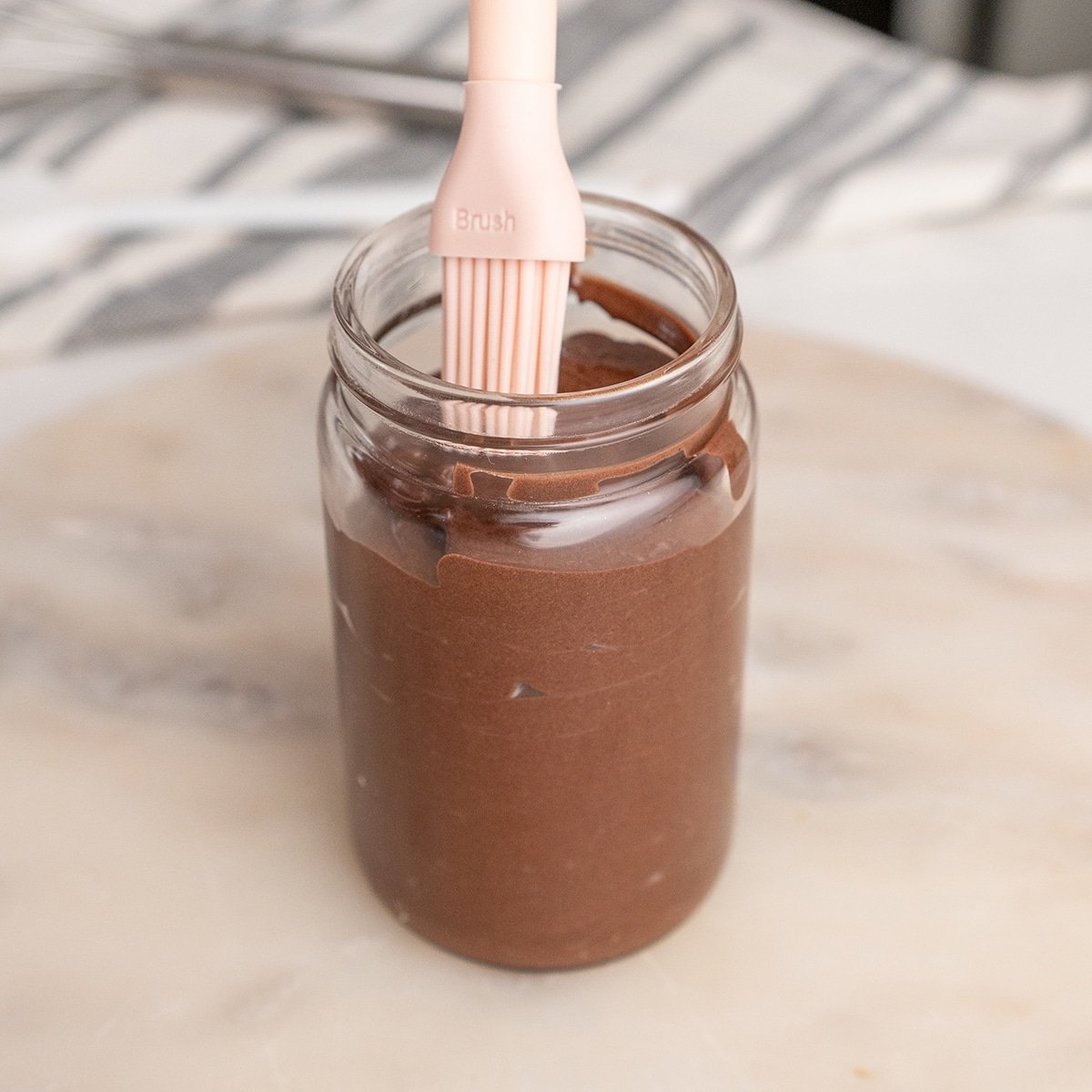 chocolate cake goop in a jar with a silicone brush