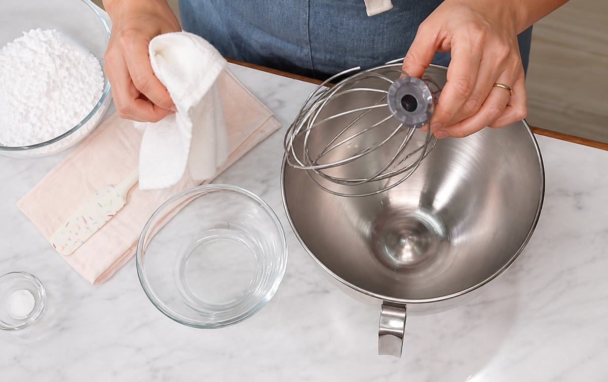 Hands wiping down tools with vinegar.