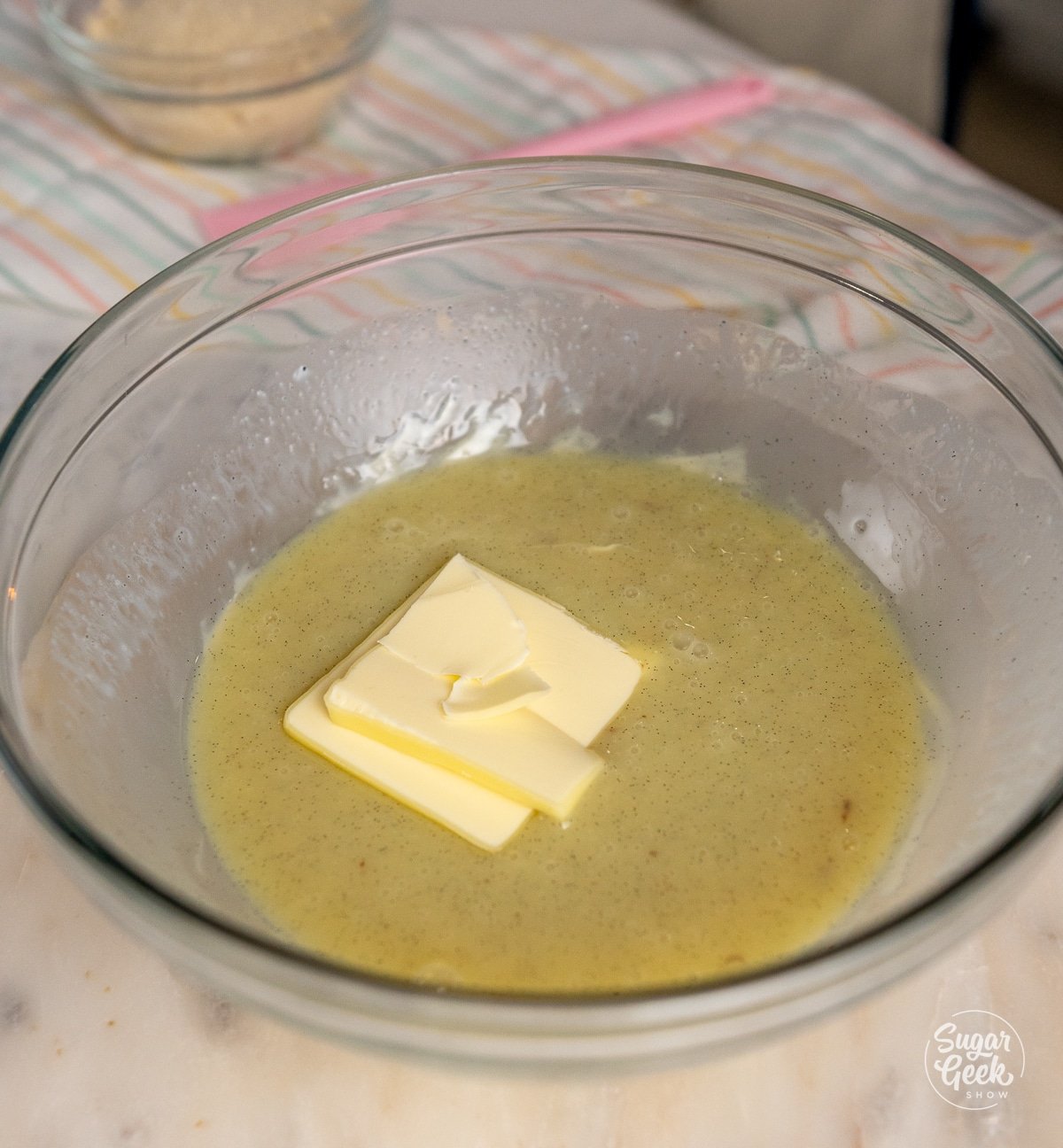 block of butter in a bowl of white chocolate ganache