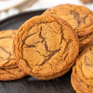 molasses cookies piled on a black plate