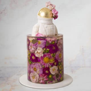 Cake decorated to look like a 3D jelly flower cake with astronaut topper