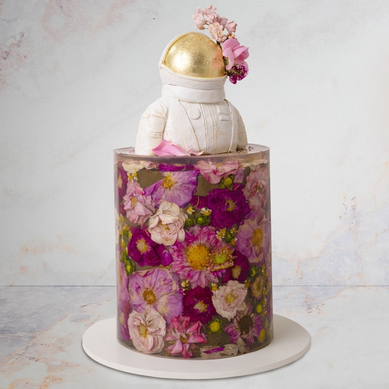 Cake decorated to look like a 3D jelly flower cake with astronaut topper
