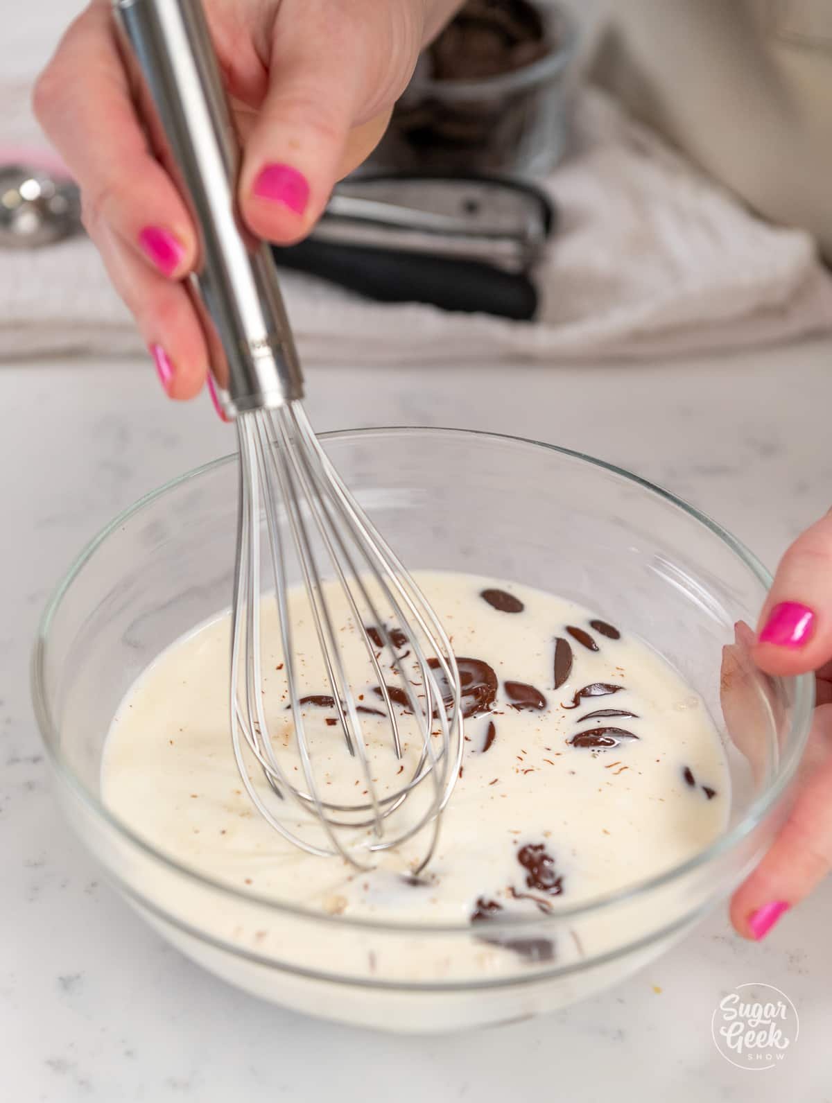 hands pushing down chocolate and cream with a whisk