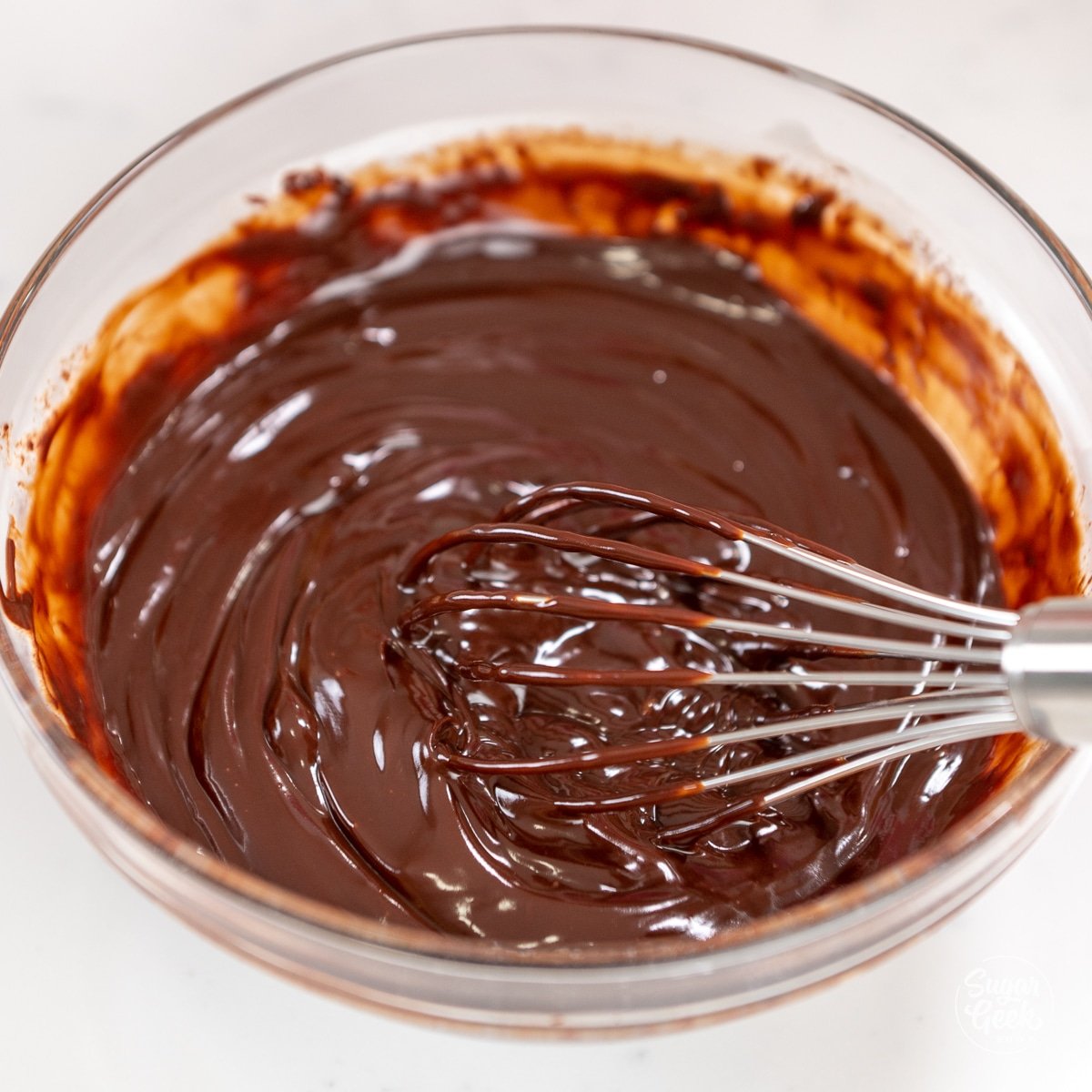 whisk mixing together ganache in a bowl