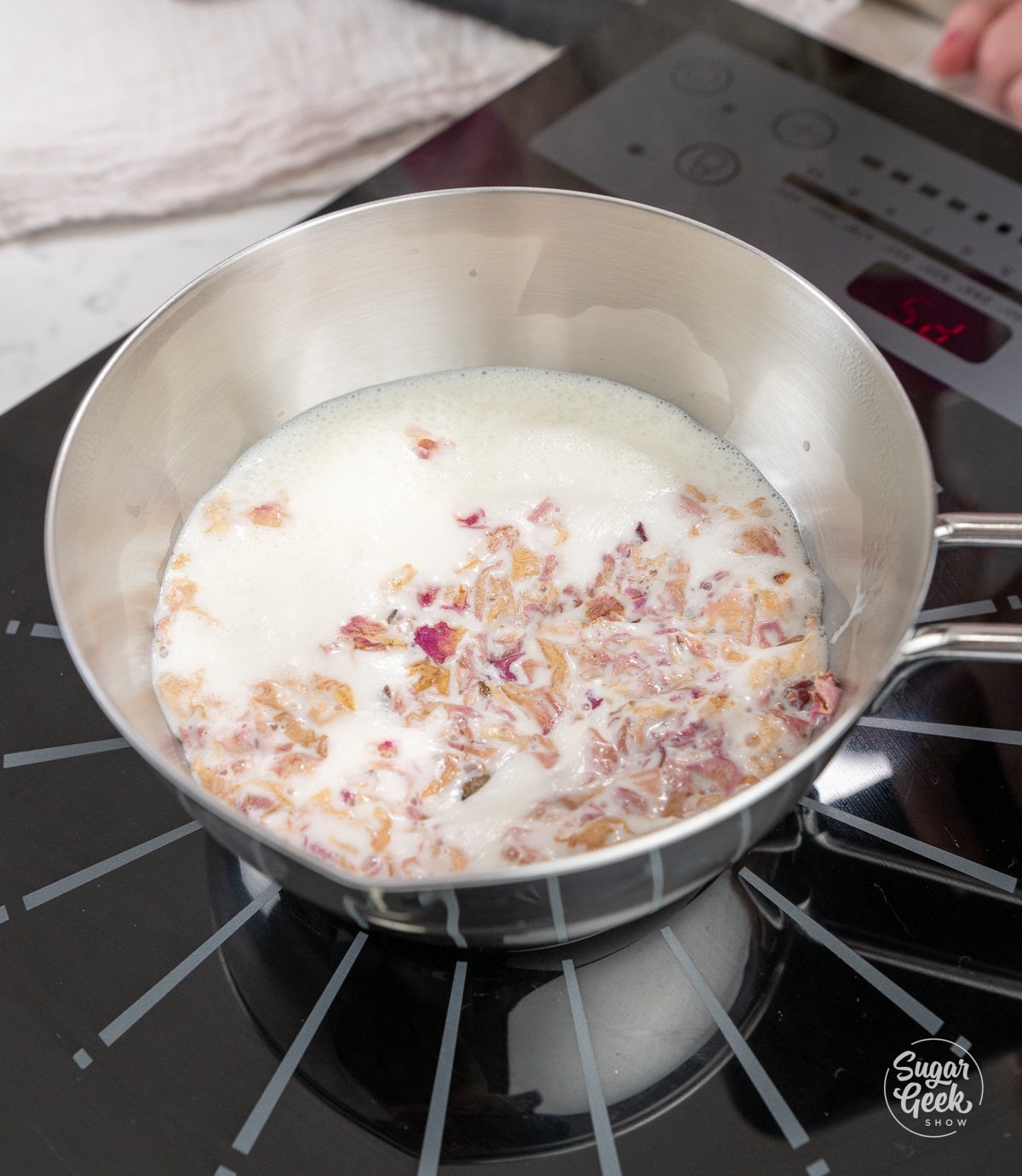 rose petal infused cream steaming in a saucepan