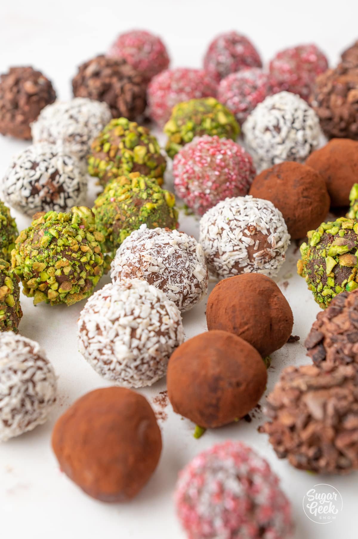 chocolate truffles covered in various toppings on a sheet tray