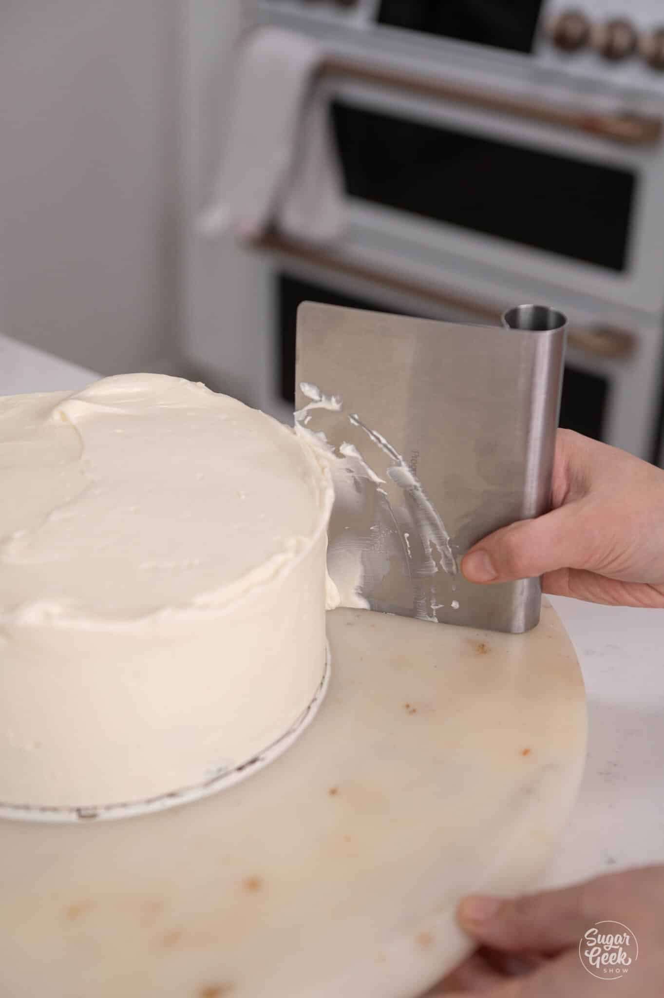 hand smoothing buttercream with a benchscraper