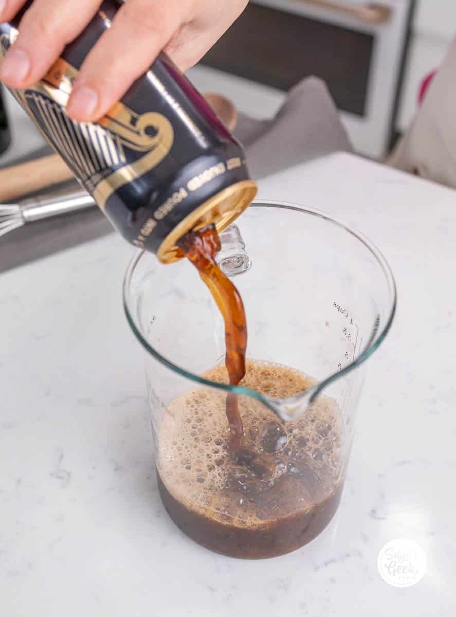 hand pouring Guinness into a measuring cup