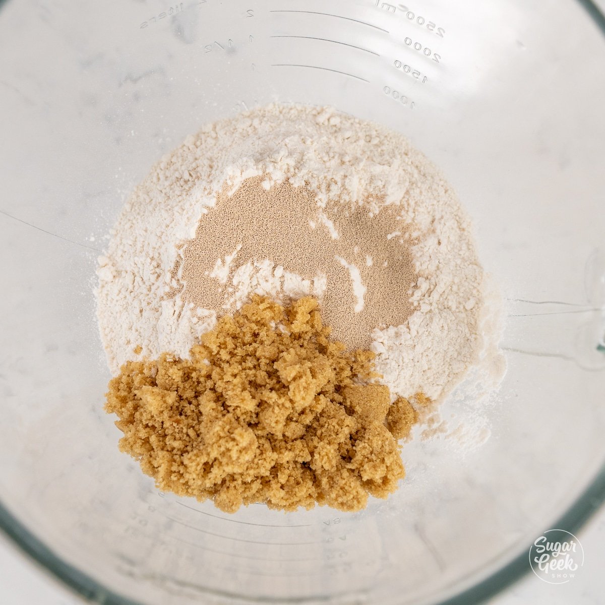 yeast, flour, and sugar in a glass bowl
