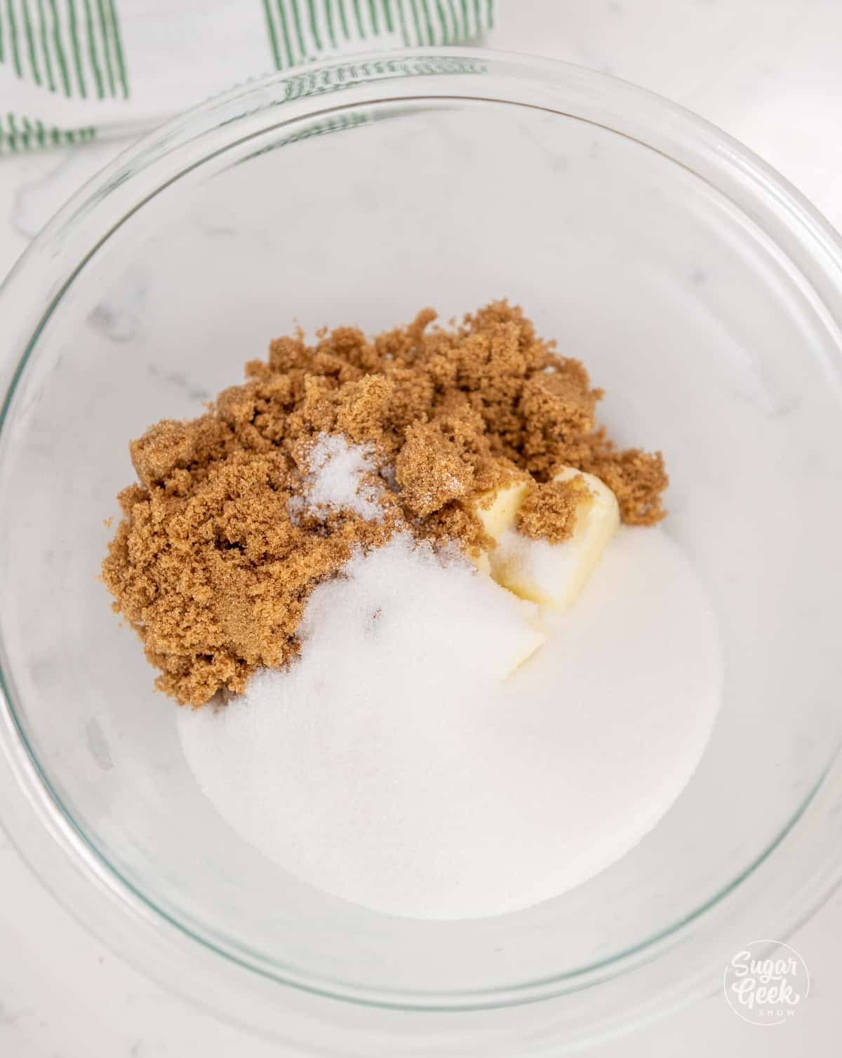 White sugar, brown sugar, and butter in a glass bowl.