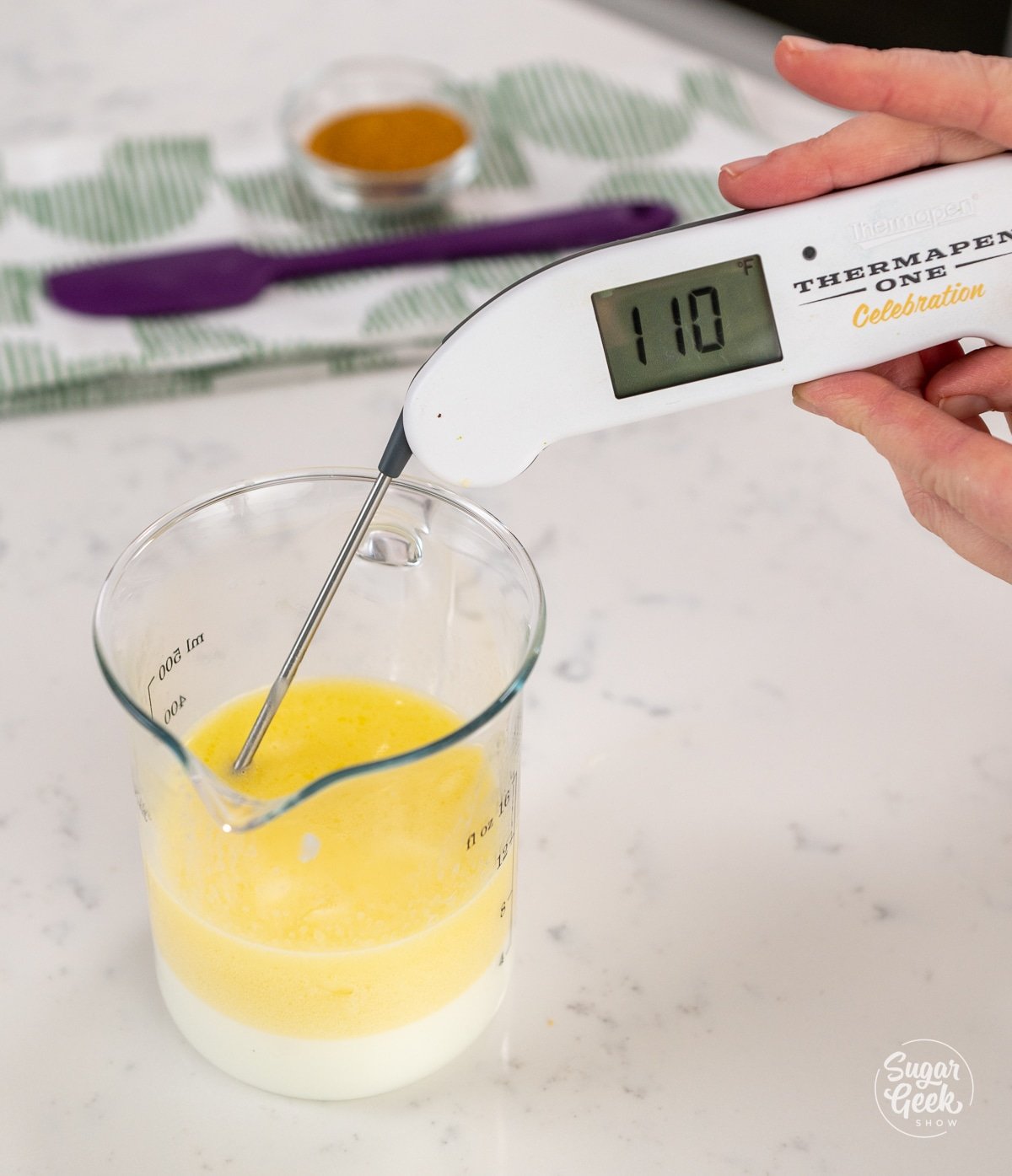 melted butter and milk in a container with a thermometer reading 110