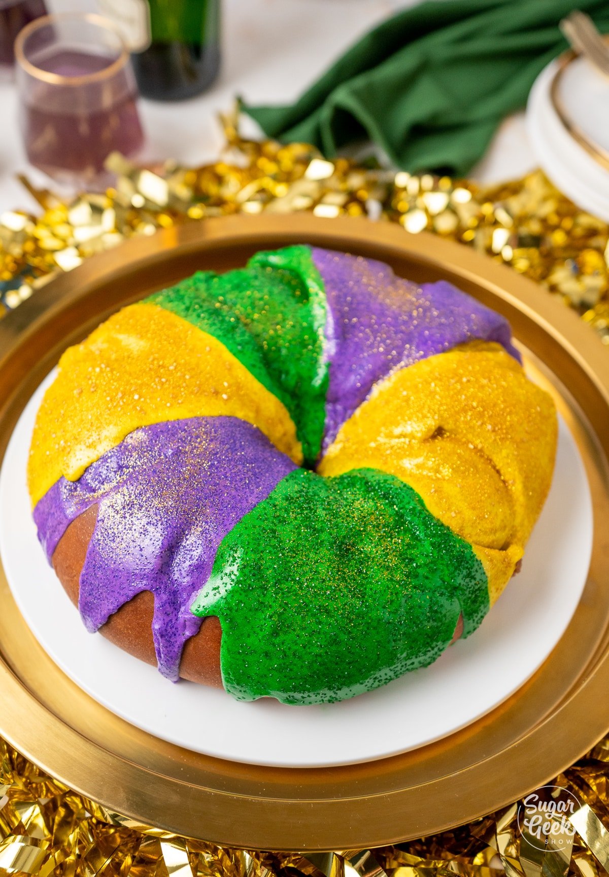 gold, green, and purple king cake on a platter