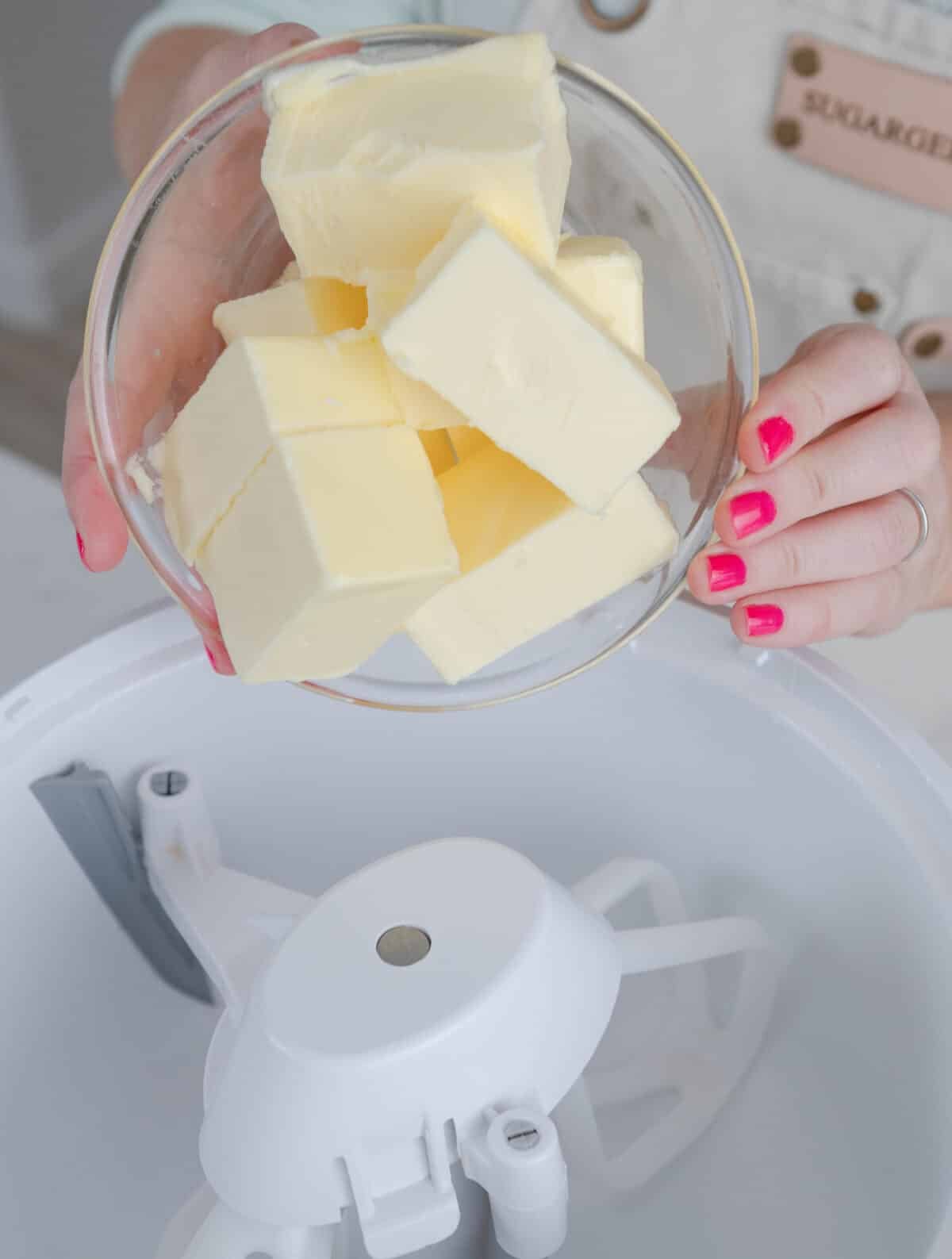 hands adding a bowl of butter into a stand mixer