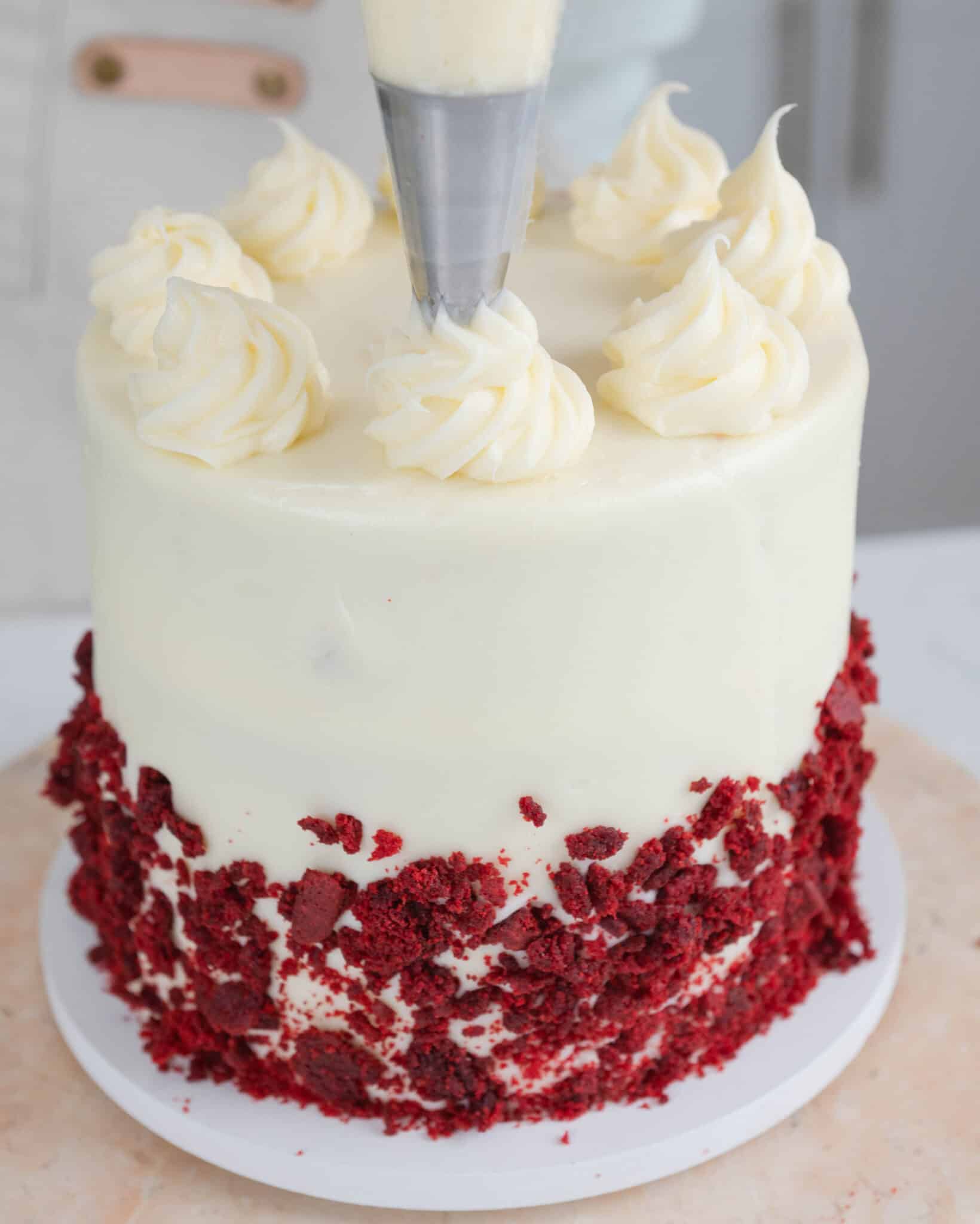 piping dollops on a red velvet cake