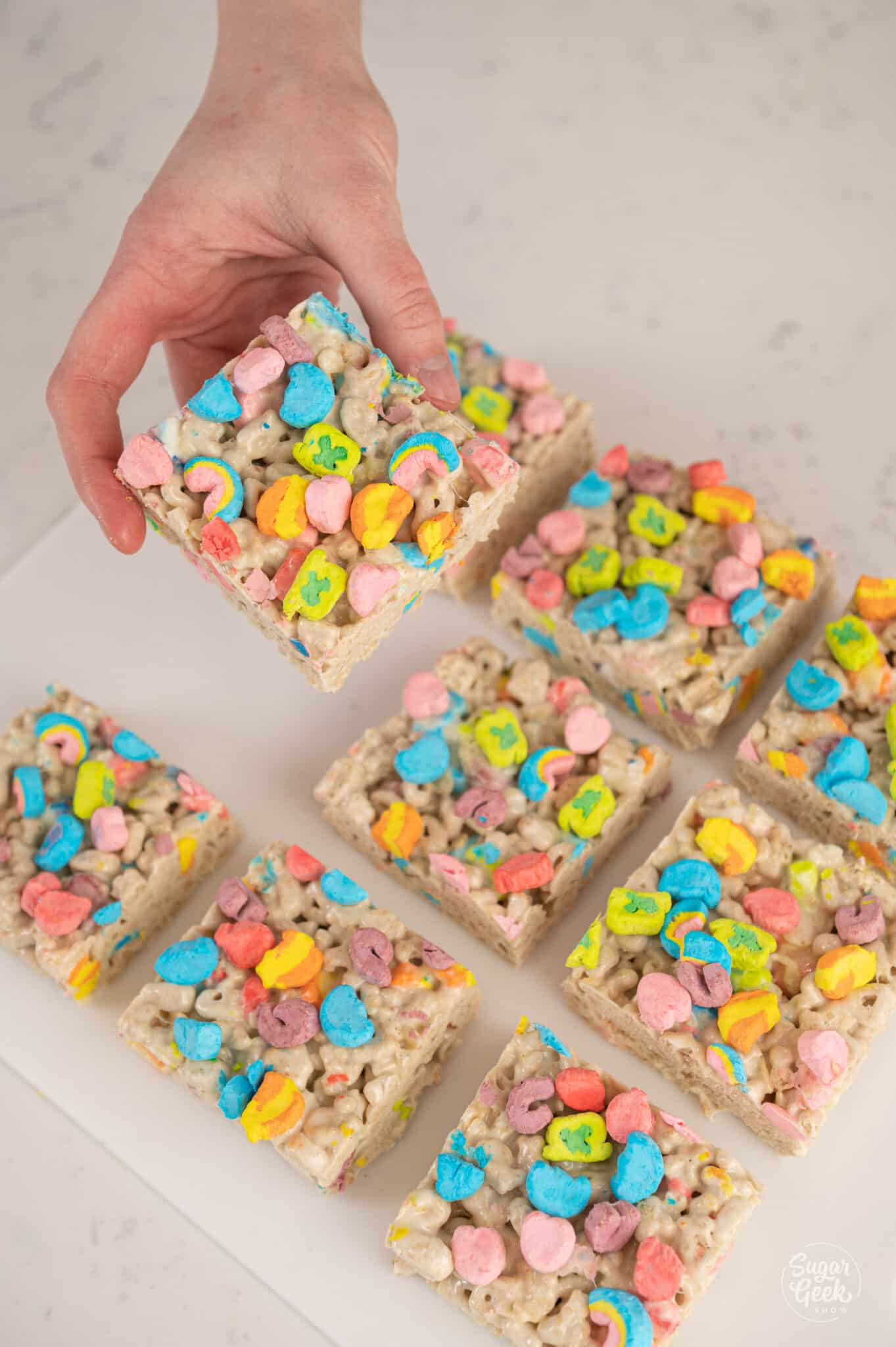 hand holding a rice krispie treat with square treats around it
