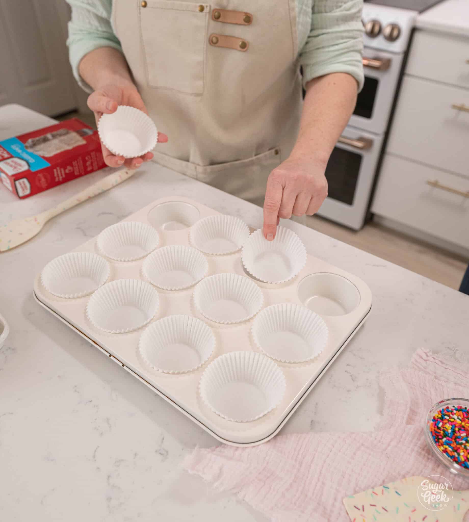 hands lining cupcake pans with liners