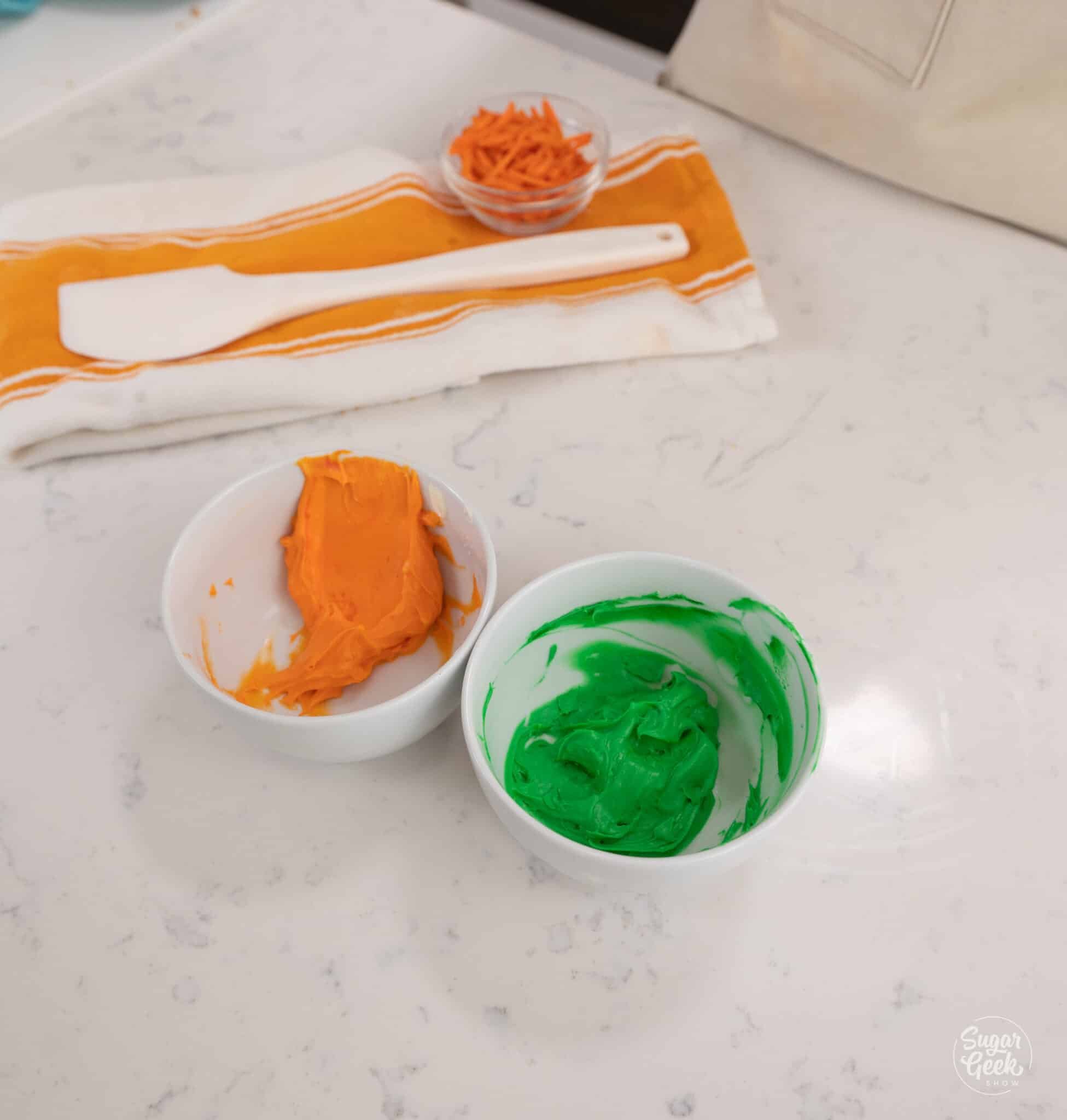 bowls of orange and green frosting