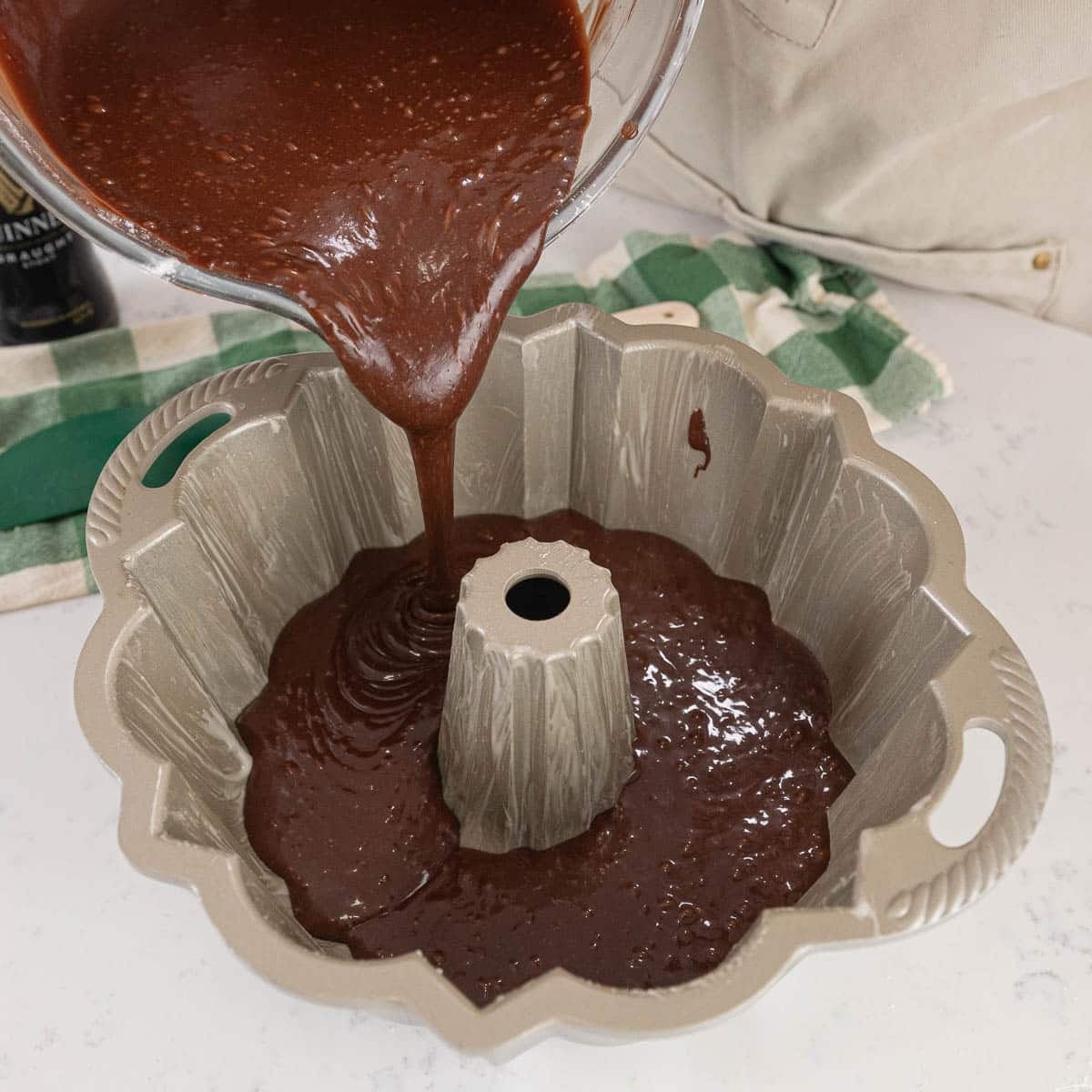 guinness cake batter being poured into a bundt cake pan