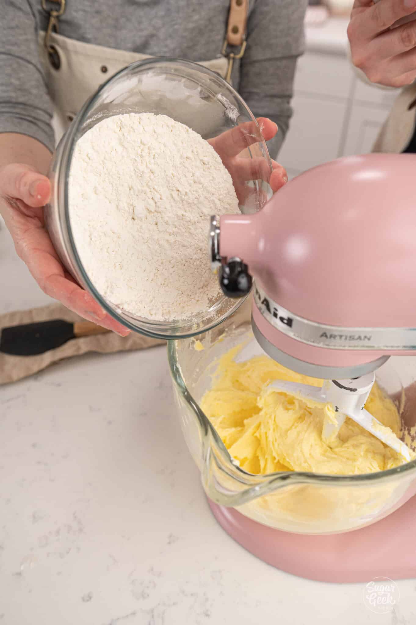 adding a bowl of flour to a glass stand mixer bowl