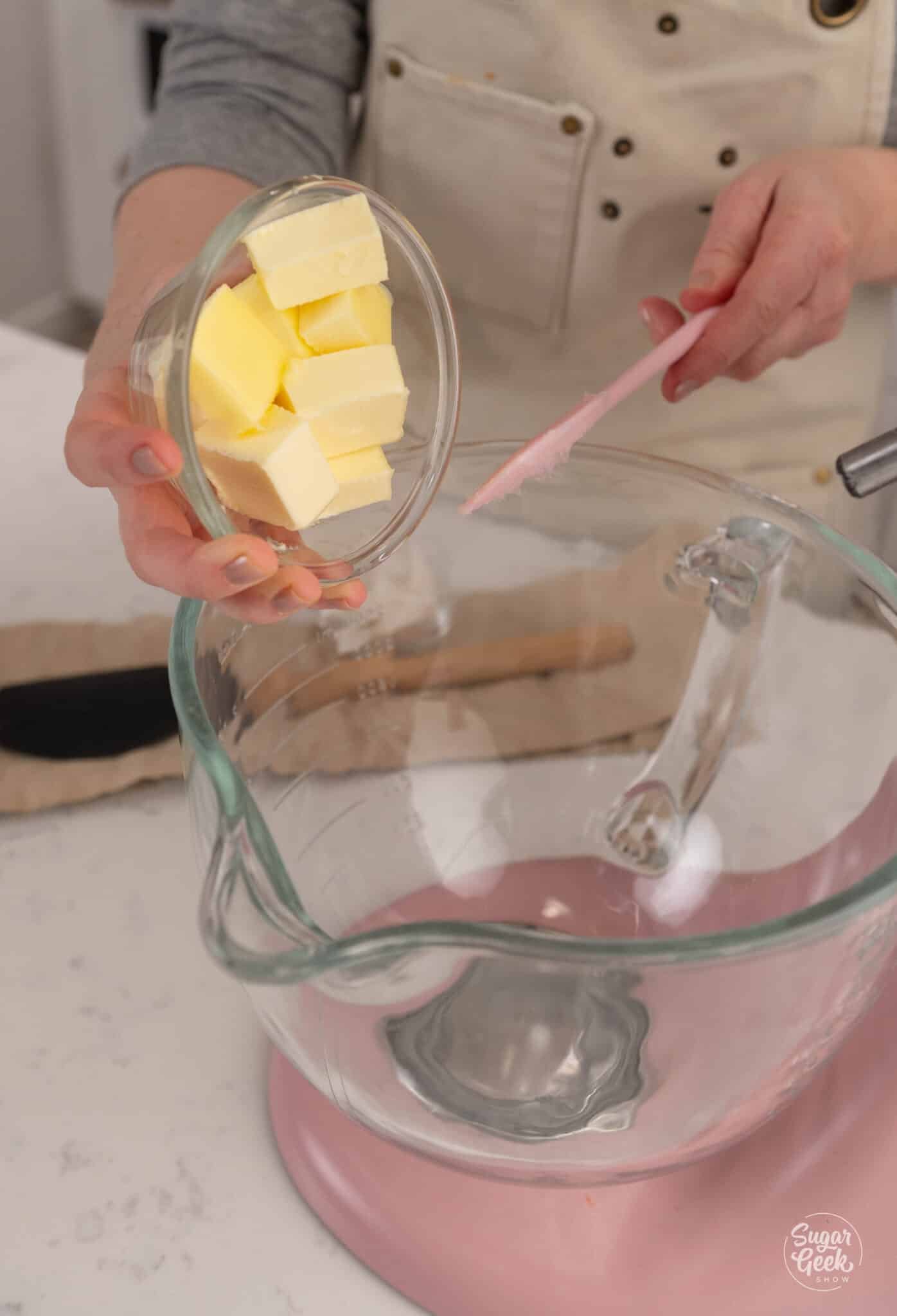 adding a bowl of butter to a glass stand mixer bowl