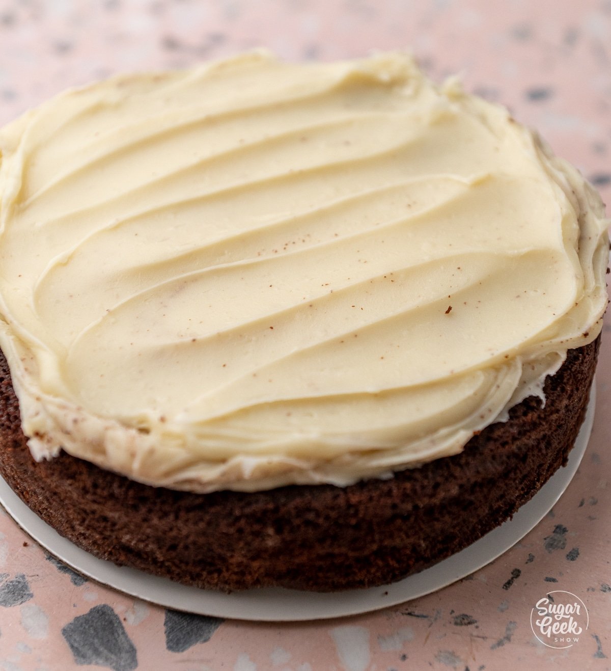 white chocolate ganache spread on top of a layer of chocolate cake